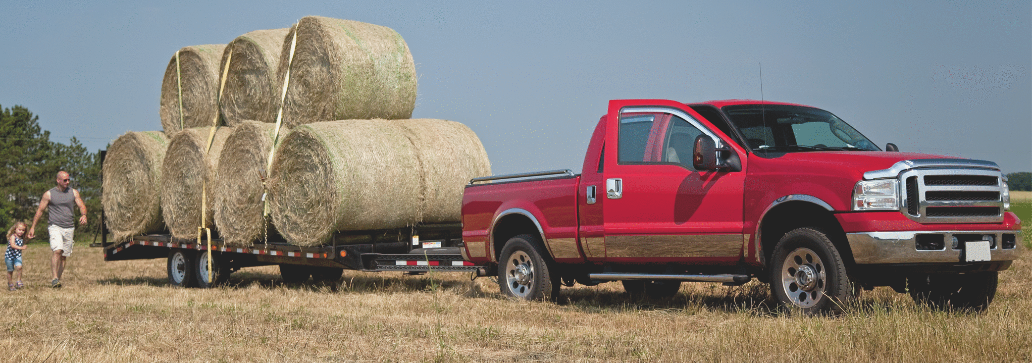 Pickup truck in a Farmer's field loading hay